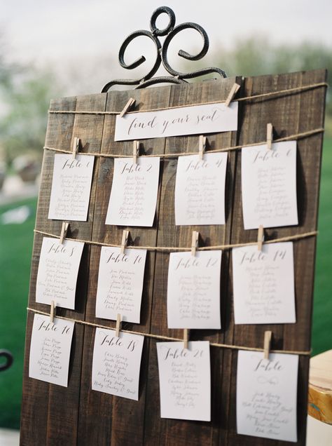 Trilogy at Vistancia Wedding | A wooden guest seating chart with calligraphy writing on paper strung by clothespins along a string | www.weddingsatvistancia.com | Leslie D. Photography Diy Wedding Seating, Wedding Seating Chart Board, Wedding Table Assignments, Seating Chart Wedding Diy, Wedding Table Seating Chart, Reception Seating Chart, Diy Seating, Table Seating Chart, Table Assignments