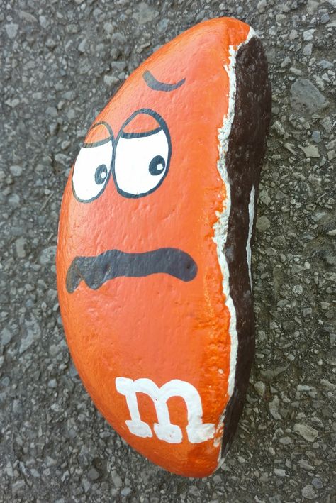 Broken m & m rock painting M&m Painted Rocks Ideas, Rock Painting Ideas Weird Shapes, Rock Painting Ideas Food, Weird Shaped Rock Painting Ideas, Rocks Painted As Food, Painted Rocks Kids, Rock Painting Ideas Easy, Painted Rocks Diy, Paint Rock