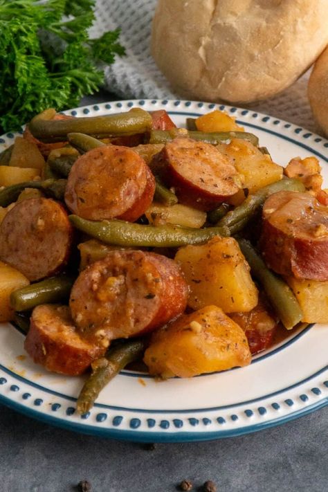 Close-up of crock pot sausage potatoes and green beans on a white plate. Slow Cook Sausage, Sausage Potatoes And Green Beans, Sausage Potatoes Green Beans, Crockpot Sausage And Potatoes, Crock Pot Sausage, Smoked Sausage And Potato Recipe, Sausage Crockpot Recipes, Sausage And Green Beans, Sausage Slow Cooker