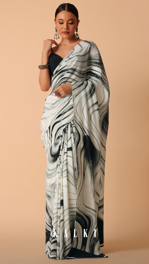 Put forth your unique and fun style this festive season by stepping out in this dual-tone saree. Decked in serene white and bold blacks, it is made from luxurious satin fabric. Enhanced with abstract prints, it is elevated with sparkly stones all-over. Paired with an unstitched blouse piece, this drape exudes a sophisticated and elegant vibe. White Satin Saree, Pranali Rathod, Satin Saree, Fun Style, Stepping Out, Printed Sarees, Bold Black, White Satin, Blouse Styles