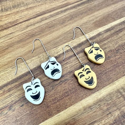 Handmade polymer clay theater masks in comedy and tragedy dangle earrings. Surgical stainless steel long ear wires. Hypoallergenic & tarnish resistant. Each pair sold separately. White Gold  Items:  ❤️All my items are handmade in small batches by me. I tend not to make exact duplicates so many items are one of a kind.  Handmade items may have slight imperfections. These do not effect the function or quality of the product. Some might say they add character.  💜Colors may differ. I try my best to capture items true look, however, screens can cause variations. 💙I make custom orders upon request.  Order Processing & Shipping: 💚All orders will be processed and shipped within 1-3 Business Days, unless otherwise stated.  💛Seller is NOT responsible for any packages once USPS has marked the pac Theater Mask Design, Theater Earrings, Artistic Theater Eye Mask, Mask Theatre, Oni Mask Earrings, Theater Mask, Theater Masks, Gold Items, Theatre Masks