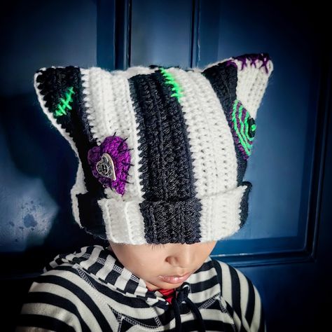 Handmade crochet cat beanie with cat ears with ribbing, buttons, and stitching details. Size: For elderly emo heads 21+ inch in circumference. May fit emo child's head loosely. Length is 9-10 inches long for folding outwards if preferred. Color: black and white stripes with purple and bright green details. Color may vary slightly due to monitor settings. Stitch design and placements may vary slightly as each one is handmade by moi. Materials: acrylic yarns (stretchy) and buttons  Made to order i Sally Nightmare Before Christmas Hat, Cat Ear Hats Crochet, Shark Beanie Crochet, Crocheted Halloween Hats, Crochet Square Hat Pattern Free, Odd Crochet Patterns, Tapestry Crochet Hat, Crochet Scrap Beanie, Halloween Crochet Beanie