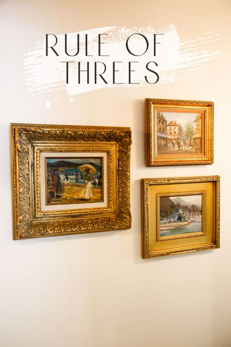 Three gold picture frames arranged on a cream colored wall. The rule of threes.simple design tip to make life easy and your home awesome! Arranging Wall Decor, Wall Gallery Layout Templates, Five Frame Gallery Wall, Ways To Hang 3 Pictures On A Wall, Arranging 3 Pictures On Wall, Paintings Arrangement On Wall, Small Gallery Wall 3 Frames, Arranging Art On The Wall, Family Portrait Framing Ideas