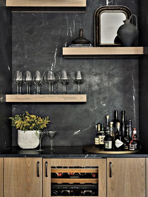 Off the kitchen and across from the dining area, a bar features Negresco granite from Serrano’s Marble & Granite in a leathered finish. The white oak cabinetry and floating shelves are the work of Modern Kitchen Center. The wine refrigerator is Sub-Zero. Negresco Granite, Rh Dining, Modern Oak Kitchen, Wet Bar Designs, Dallas House, Leather Granite, Modern Home Bar, Natural Stone Veneer, Luxury Bar