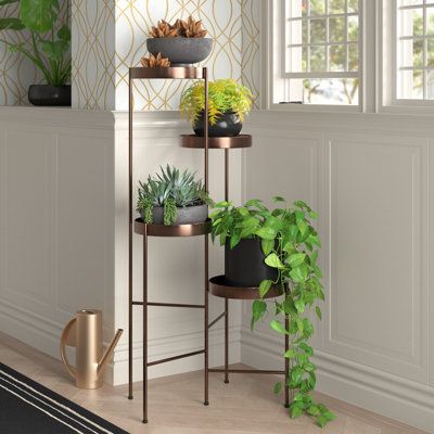 Filling your home with lush green plants, sweet succulents, and fragrant herbs is a snap with this multi-tiered plant stand. It features four round shelves that span a total of 10” in height, adding spatial dimensionality to your home. Crafted from iron, it is available in several neutral hues, so you’re sure to find the one that best suits your existing colour scheme or decor. Plus, it weighs 8.48 lbs. so it is pretty easy to move from a shady spot to a sunny one, or from your kitchen to your b Planter Stand Indoor, Plant Stand Metal, Elegant Home Office, Round Shelf, Support Pour Plante, Modern Plant Stand, Colorful Succulents, Metal Plant Stand, Decoration Plante