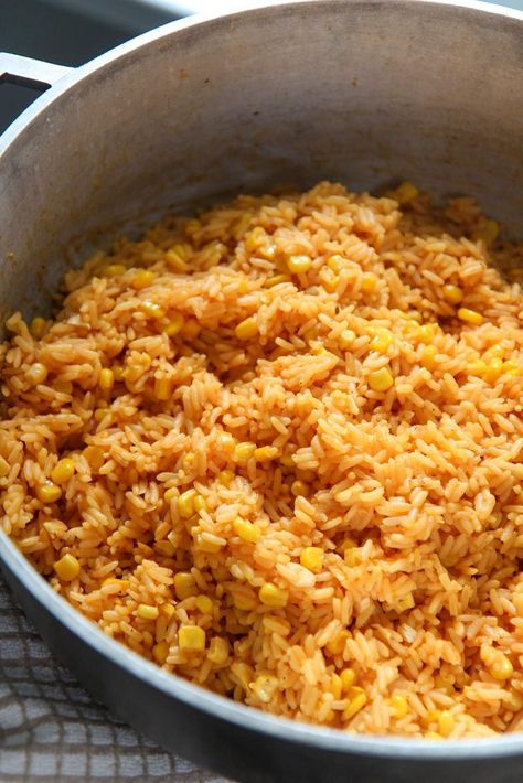 This yellow rice with corn is cooked with onions, garlic, spices, and vino seco. A Cuban staple that can be enjoyed with tomato avocado salad and pernil. Super easy to make and will feed a large crowd. #sidedish #yellowrice Rice With Corn Recipe, Spicy Corn Dip, Yellow Rice Recipe, Rice With Corn, Rice And Corn, Yellow Rice Recipes, Honey Roasted Carrots, Parboiled Rice, Avocado Tomato Salad