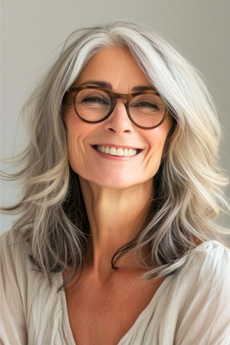 This over 60 mid-length hairstyle exudes elegance with its voluminous, flowing silver tresses. The gentle layered waves complement the contours of your face, highlighted by the smart look of the glasses. Click here to see more stunning hairstyles for women over 60 with glasses. Hair And Glasses, Haircut Gray Hair, Long Hair Highlights, Classy Hairstyles, Hairstyles With Glasses, Haircut For Older Women, Hairstyle Look, Chic Hairstyles, Women Over 50