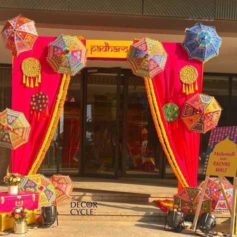 Entrance for Traditional and quirky Mehendi Decor with umbrellas and flowers. Colorblocking decor.

#colorfuldecor#mehendi#mehendidecor#mehendiideas#indianwedding#weddingdecor#weddingdecoration#mehendidecor#weddingdesign#thedecorcycle Dandiya Night Decoration For Navratri, Rajasthani Haldi Decor, Mayra Decoration, Mehendi Entrance Decor, Entrance Decor For Wedding, Rajasthani Theme Decoration, Garba Decoration Ideas Navratri, Garba Decoration Ideas, Haldi Entrance