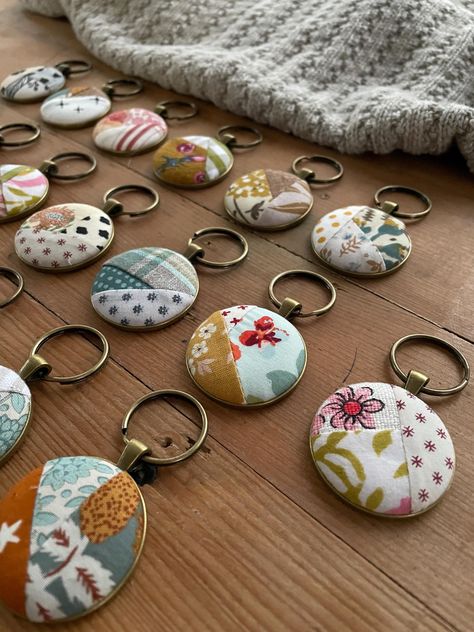 Gathered up some of my favorite bits of fabric to create these pretty key rings.  Each is made to be like a mini quilt, there are 20 included in this.  First I stitch up tiny little crazy quilts that are them made into buttons.  Next they are inlaid on a metal bezel and suspended from a keyring. Each bezel measures 1.5 inches and comes suspended from a 1 inch split ring. This listing is a bulk grouping of my quilt keychains.  I created this for when you need a little token of appreciation for la Sew Gifts, Fabric Keychain, Sewing Machine Repair, Quilt Retreat, Keychain Fob, Handmade Ideas, Mini Quilt, Hair Stuff, Tree Ideas