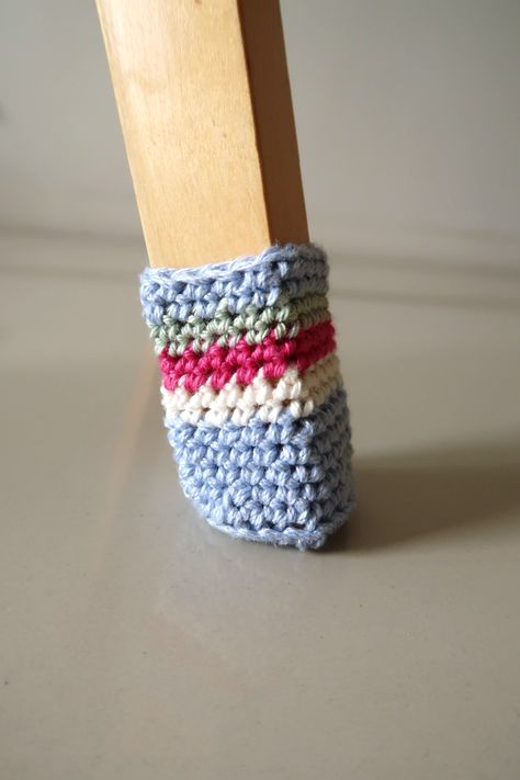 "Ditch those annoying felt pads on the bottom of your chair legs, and upgrade to these adorable DIY crochet chair socks. They’ll protect your floors, silence your chairs, and the best part-- they’re easy to clean! Make a set for each holiday or special occasion and bring instant festivity to your dining room. This fun crochet pattern is super easy and only uses a small amount of yarn, so it’s perfect for using up your existing stash.  PATTERN DETAILS • Fits 2.5cm by 2.5cm base, 5.5cm to Crochet Furniture Socks, Crochet Around The House, Crochet Table Leg Socks, Quick Useful Crochet Projects, Crochet Chair Socks Free Pattern, Crochet Chair Cover, Crochet Chair Socks, Chair Socks Pattern, Crocheted Socks