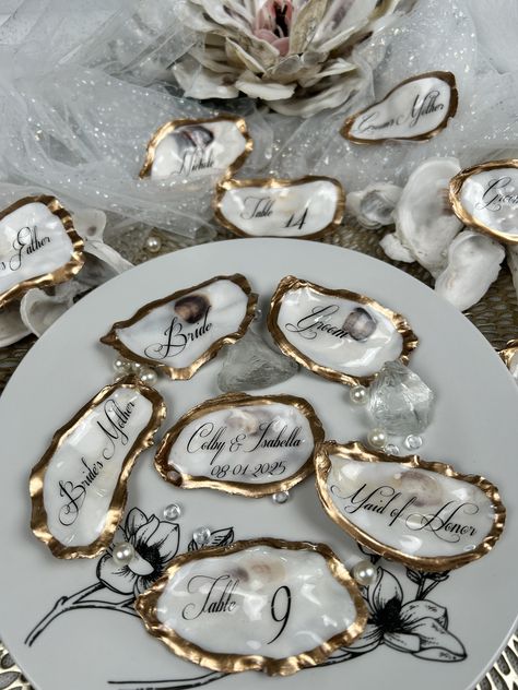 Your guest will be surprised to know that they have a very special keepsake to take with them. Your tables will be stunning and elegant with the table numbers on these shells that match the guest’s keepsakes. A thoughtful gift that they will always cherish on their very special day. Each place card is uniquely stunning for your guests. Oyster Table Numbers, Coastal Wedding Tablescape, Oyster Shell Place Cards, Oyster Table, Oyster Wedding, Shell Place Cards, Natural Place, Murrells Inlet Sc, Oyster Shell Crafts