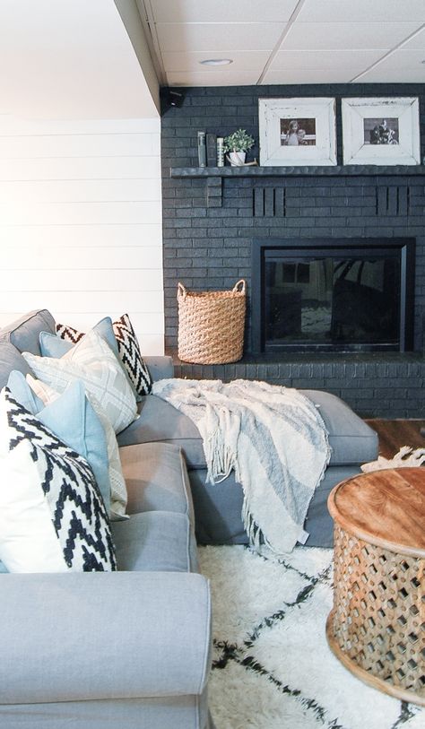 A gorgeous dark gray painted fireplace looks stunning paired with a bright white plank wall! - www.littlehouseoffour.com Grey Painted Fireplace, White Plank Walls, Painted Fireplace, Painted Brick Fireplace, Painted Brick Fireplaces, Nautical Living Room, Brick Fireplace Makeover, Paint Fireplace, Black Fireplace