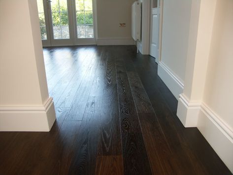 This rich dark fumed oak floor comes in 140mm wide engineered double fumed oiled Oak. Made from natural grade oak this wood is perfect for those who are in search of a less rustic, classic look for their room. The narrower planks create a crisper more professional style that works brilliantly with the micro beveled edges to create a more modern looking and yet traditional floor. Man Cave Flooring Ideas, Dark Oak Flooring, Distressed Floors, Wood Floor Colors, Hardwood Floors In Kitchen, Rustic Wood Floors, Engineered Oak Flooring, New House Living Room, Dark Wood Floors