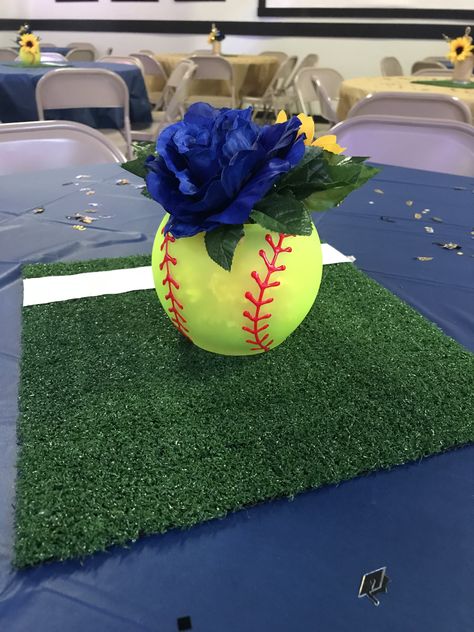 Softball themed centerpieces. Spray painted glass bowls found at Dollar Tree and then stitched painted with slick paint. Grass found at Lowe’s and hubby added the foul line with white duck tape. Accented with flowers to match with school colors. Tennis Shoe Centerpieces Table Decorations, All Sports Banquet Decorations, Softball Flower Arrangements, Softball Sweet 16 Party Ideas, Softball Table Decorations, Softball Table Centerpieces, Softball Centerpieces Banquet, Softball Graduation Party Ideas, Softball Centerpieces Table Decorations