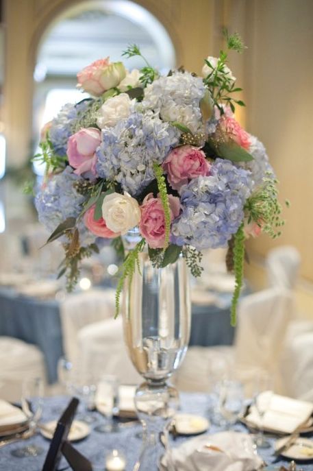 This elegant centerpiece is Made of blue hydrangea, pink peonies, white roses, hanging amaranthus, and seeded eucalyptus. Pastel perfection. Wedding Flowers Blue Hydrangea, Hydrangea Pink, Blue Wedding Centerpieces, Hydrangea Bouquet Wedding, Pink Flower Arrangements, Wedding Flowers Hydrangea, Hydrangeas Wedding, Blue Wedding Flowers, Elegant Centerpieces