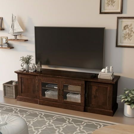 Combine beauty and functionality in this solid Furniture of America Walder vintage-style TV stand. Crafted for large flat-screen TVs, this wide console features four cabinet doors covering roomy shelves for hiding and protecting all your electronic and media equipment. A warm, dark-oak finish gives this traditionally styled piece a vintage look that's just right for a den or family gathering place. Two central glass-paned doors allow for remote-control use, while the shelves behind them are adju Walnut Tv Stand, Tv Cabinet Design, Muebles Living, Clutter Free Home, Multifunctional Storage, Living Comedor, Tv Stand Wood, Cable Box, Built In Cabinets