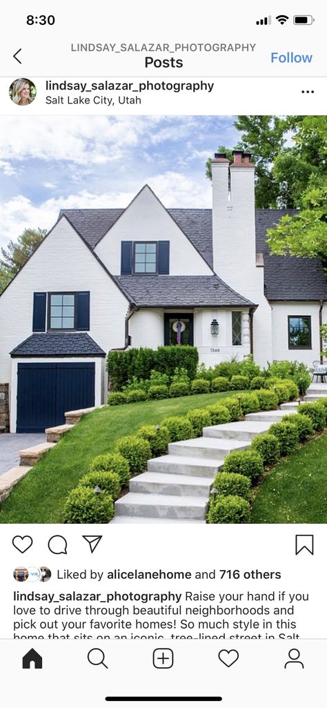 Cream House With Blue Shutters, Light Gray Siding Exterior With Shutters, Cream House Gray Shutters, White House Tan Garage Door, Light Beige Siding With Black Shutters, White House With Brown Garage Doors, Blue Garage Door, Cream Colored Background, Navy House Exterior