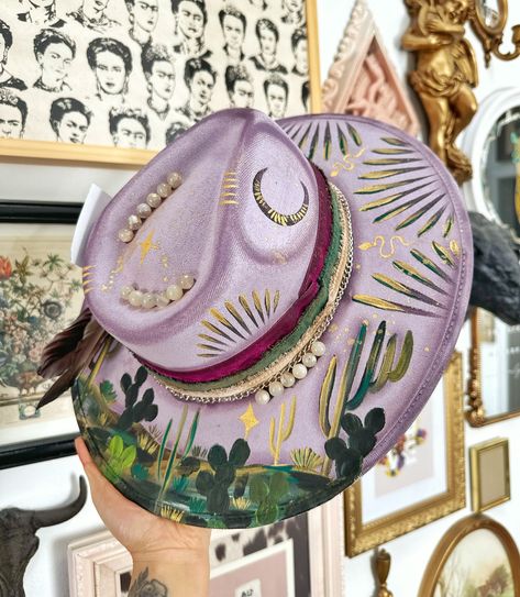 Highly requested lilac desert outlaw hat just went up! 🤩 Genuine flower agate stones used on this hat! Hand painted and handmade 🩵 #hats #hat #fedora #fedorahats #fedorahat Painted Wide Brim Hat, Custom Fedora Hat, Custom Fedora, Decorated Hats, Textured Hat, Custom Made Hats, Handmade Hats, Hat Fedora, Hat Ideas