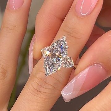 Ori Vechler on Instagram: "Most Underrated Shape In Diamonds🤍 5ct D Color Marquise Shape With Hearts Side Stones💞 Marquise Looks Larger Than Most Shapes With An Edgy & Longish Looks, Gives It The Most Unique Look🫶🏻  ___________________  #marquise #marquisediamond #hearts #3stonering #diamondring #ring #dcolor #unique #outofthisworld #uniquejewelry #shape #jewels #engagementring" Diamond Ring Marquise, Dazzling Marquise Diamond Ring With Center Stone, Dazzling Marquise Cut Center Stone Wedding Ring, Luxury Marquise Cut Diamond Ring With Accent Stones, Luxury Marquise Center Stone Wedding Ring, Dazzling Marquise Cut Diamond Accented Ring, 3 Stone Rings, January 13, Marquise Diamond