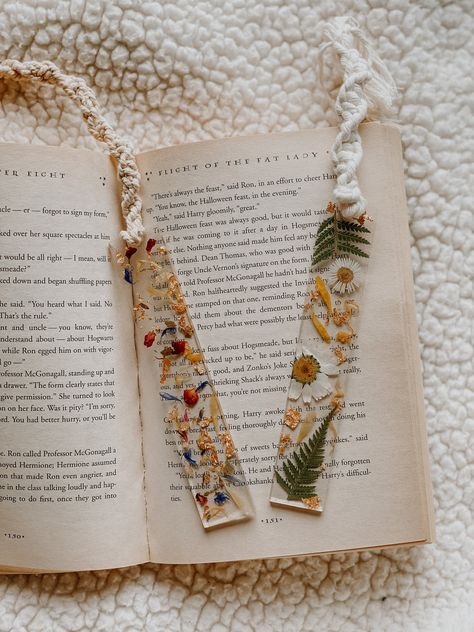 A handmade, aesthetic, cottagecore resin bookmark that is created using pressed wildflowers, leaves, and gold flakes, finished with a macrame chain tassel. Every bookmark is handmade and made to order - meaning each bookmark will be unique to you as no two flowers are ever the same!  Regular bookmarks measure roughly 5.5 x 1 inches. Minis measure roughly 3.5 x 1 inches. (Not including tassel length, which varies.) Please note: Do not leave bookmark in a hot place (or sitting in a hot mailbox) because it will become flexible and start to bend. If this does happen, place the bookmark in a cool place on a flat surface and it will harden again. Please also be aware that because every bookmark will be different, colors may vary slightly due to the natural color differences in flowers. These pre Resin Flower Bookmark, Resin Bookmarks, Flower Resin Jewelry, Resin Crafts Tutorial, How To Make Bookmarks, Diy Bracelet Designs, Diy Resin Art, Gold Flakes, Great Tattoos