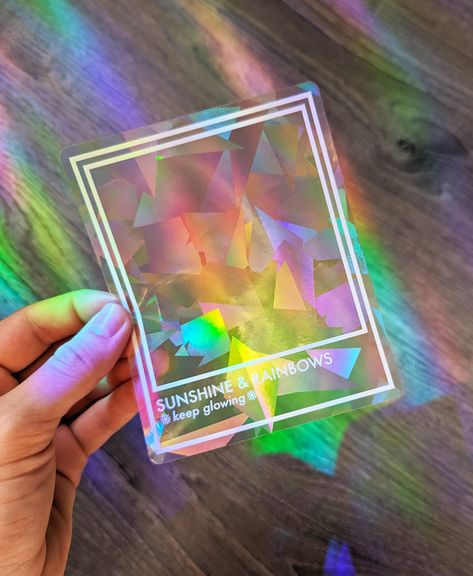 Step into a world of enchantment with our Prismatic Rainbow Making Suncatcher Stickers! 🌈✨ These delightful window decals are a really cool way to infuse your space with vibrant rainbow beams! 😍🌈  Crafted with meticulous attention to detail, our rainbow makers feature our original designs printed in white on a prismatic sticker that refracts light, creating a mesmerizing kaleidoscope effect. Spread joy by surprising friends & loved ones with these! As a birthday gift, housewarming gift, or ju White Rainbow Aesthetic, Suncatcher Vinyl, Rainbow Branding, Suncatcher Stickers, Rainbow Things, Suncatcher Sticker, Aesthetic Rainbow, Indoor Window, Brand Ideas