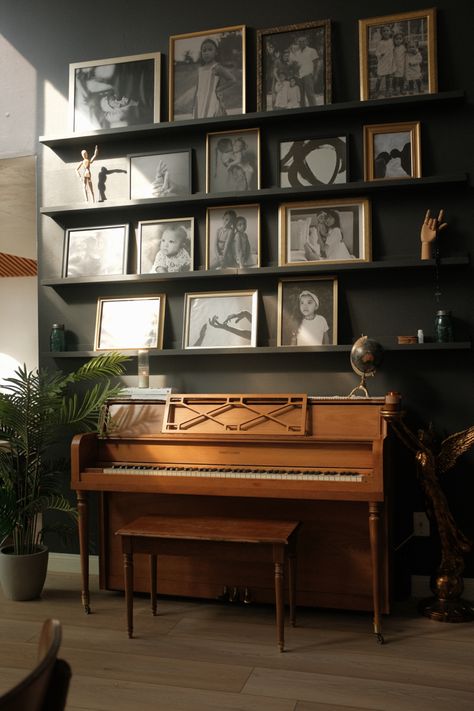 Gallery wall decor using gold picture frames atop a piano. Black Wall With Frames, Decor Around Piano, Art Above Piano Living Rooms, Wall Piano In Living Room, Piano Gallery Wall, Wall Piano Decor Ideas, Gallery Wall Over Piano, Above Piano Wall Decor, Style A Piano