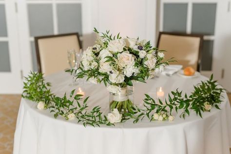 Confetti on Instagram: "Adding a vase for your bouquet as well as some loose greens to your sweetheart table is a great way to repurpose your bouquet and add something special to your sweetheart table!  Photographer:  Slide 1: @juliajanepics  Slide 2: @matt_agan  Slide 3: @_summerbarnhart   #ctwedding #ctweddingflorist #reddingflorist #ridgefieldflorist #ctflorist #westonflorist #wiltonflorist #westportflorist #fairfieldcountyflorist #florals #sweethearttable  #bouquet #bridalbouquet  #summerweddinginspo #weddinginspo #florals #weddingflorals #sweetheartflorals #receptionflowers #lisianthus #roses #Anemone #ranunculus #scabiosa  #roses #carnations" Greenery On Sweetheart Table, Small Sweetheart Table Arrangement, Sweetheart Table With Bridal Bouquet, Greenery Runner, Green Wedding Flowers, Sweetheart Table Wedding, Reception Flowers, Head Table, Wedding Tablescapes