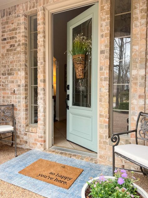 County Road 407 brick house with opened light mint colored door, blue rug and iron chairs Front Door Color With Light Brick, Front Door Brown Brick House, Front Door Colors With Tan Brick, House Doors Colors, Mint Door, Brown Brick Houses, Colored Door, Best Front Door Colors, Brick Porch