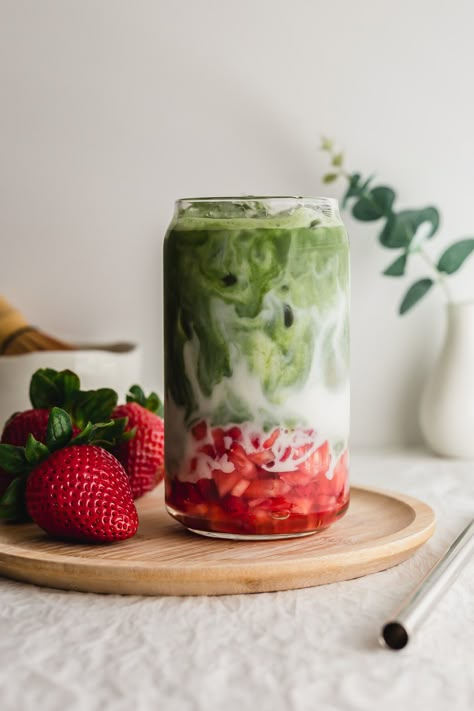 Matcha strawberry latte in a glass on a wooden plate. Strawberry Milk Matcha, Matcha Shop Aesthetic, Strawberry Matcha Recipe, Cafe Drinks Ideas, Matcha Cafe Aesthetic, Strawberry Beverages, Green Drinks Healthy, Christmas Matcha, Iced Strawberry Matcha Latte