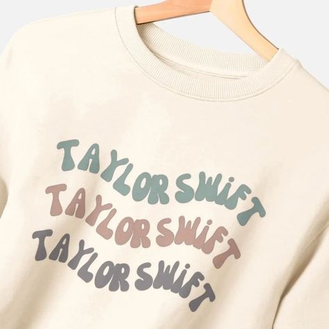 RETRO // Anyone else loving the mid-century throwback trend? We've created a Taylor Swift t-shirt inspired by the groovy fonts and muted colours, which is such a vibe. We have regular and cropped fit t-shirts, and dreamy relaxed fit sweatshirts with our retro Taylor Swift graphic. Shop link in bio. #taylorswift #theerastour #popmerch #feelgoodfashion #swifties Retro Taylor Swift, Taylor Swift Graphic, Taylor Swift T Shirt, Groovy Font, Muted Colours, Workout Sweatshirt, Muted Colors, Fangirl, Taylor Swift