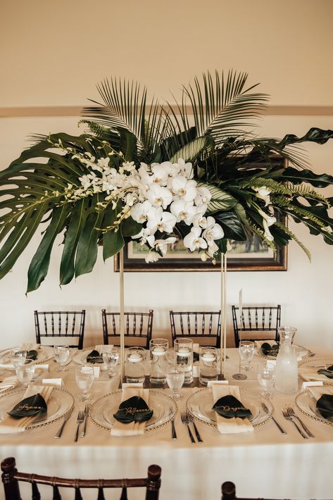 To bring this bride's vision to life, a mix of tall and low centerpieces were placed throughout her wedding reception. If you're looking for tropical inspiration, look no further thatn this centerpiece with giant monstera leaves, pal leaves, and white orchids! See more of this wedding on Here Comes The Guide! #moderncenterpiece #tropicalflowers #orchids Tropical Modern Wedding, Beach Wedding Table Settings, Modern Wedding Centerpieces, Beach Wedding Tables, Jungle Wedding, Tropical Wedding Theme, Palm Wedding, Orchid Centerpieces, Modern Centerpieces