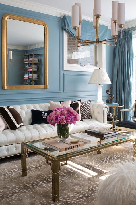 Designed by Wendy Labrum, this dusty blue living room feels refreshingly elegant and feminine thanks to the white tufted sofa, brass-trimmed coffee table and vase full of bright pink roses. Blue Couch Living, Bungalow Interior Design, Blue Couch Living Room, Sofa Pictures, Glam Living, Living Room Decor Inspiration, Interior Design Advice, Pink Living Room, Transitional Living