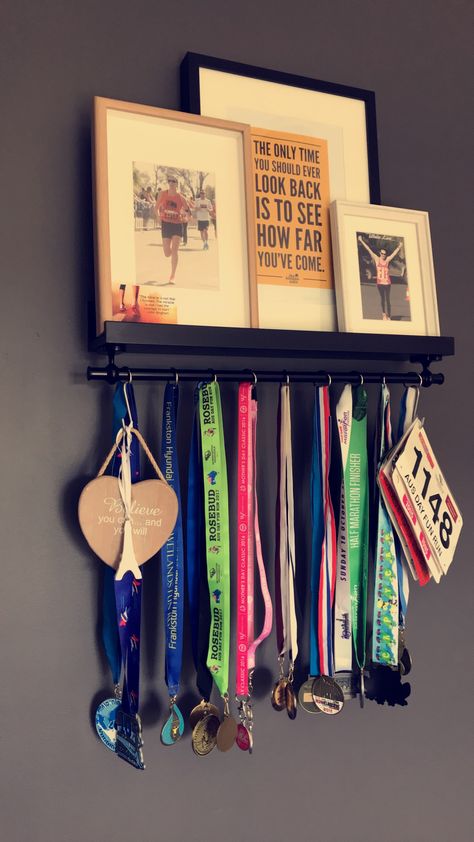 Medal hanger. Simple, easy to make. Ikea hack. All you need is a Mosslanda picture rail and a Fintorp rail. A few screw holes and you're done! Finish it off with some hooks for your medals and racebibs, plus some framed pics or inspirational quotes. How To Decorate Medals In Room, Medals Hanger Ideas, Simple Medal Display, Hang Medals Ideas, Medal Hanging Ideas, Medal Holder Diy, How To Hang Medals Display Ideas, Soccer Medal Display Ideas, Display Medals Ideas