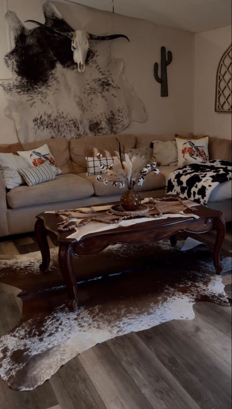 you can never have to much cowhide🤩 Black Accent Wall Living Room Western, Western Living Room Grey Couch, Apartment Western Decor, Western Themed Home Decor, Western Home Living Room, Cow Print Living Room Decor, Moody Western Living Room, Cow Skull Decor Living Room, Western Minimalist Decor