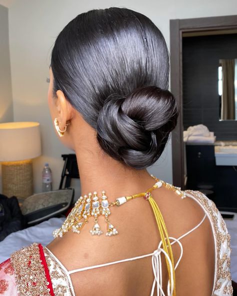 One of my favessss!! 🥨 Loved how elegant and sleek this was to go with the whole look for Shree’s wedding day Bridal makeup @_beautybyami Outfit @frontierraasuk Jewellery @thejewellerytrunk_ #weddinghair #wedding #bridalhair #bride #weddingdress #weddingmakeup #weddingphotography #weddingday #weddinginspiration #hair #bridalmakeup #updo #hairstylist #makeup #hairstyle #hairstyles #bridetobe #makeupartist #bridal #bridesmaids #weddings #love #weddinghairstyle #weddinghairstyles #weddingp... Sleek Bun Indian, Bridal Bun Front View, Indian Wedding Hairstyles Buns, Indian Updo Hairstyles, Elegant Low Bun Wedding, Upswept Hairstyles, Indian Bridal Bun, Day Bridal Makeup, Wedding Hair Bun