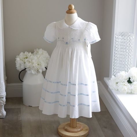 This Gorgeous Strasburg Smocked Heirloom Dress In White Size 2 Has Baby Blue Satin Trim. No Longer In Production And New With Tags Makes It A Treasure!! The Hand Smocked Bodice Has A Sweet Lattice Design With Hand Embroidered Baby Blue Details Including Rosettes With Seed Pearl Centers. White Seed Pearls Also Adorn The Waistline Making It Ever-So-Sweet!! The Puff Sleeves Are Trimmed In A Blue Satin Ribbon. The Collar Is A Sheer Organza With A White Embroidered Scalloped Edge, A Unique Collar For Baby Heirloom, Heirloom Dresses, Girls White Dress, White Flower Girl Dresses, Hand Smock, Heirloom Sewing, Lattice Design, Colorful Party, Royal Jewelry