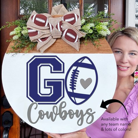 Get ready for football season with our personalized Football Door Hanger Wreath! Whether you're a die-hard fan of the Dallas Cowboys or any other team, this unique wooden front door decor is perfect for showcasing your team spirit. Our football door hanger adds a delightful touch of sophistication and individuality to any residence. Spruce up your door with a charming, festive flair for the upcoming football season. Personalize it with your favorite NFL, College, or even your child's team name a Football Themed Door Hangers, Sports Door Signs, Nfl Door Hanger, Football Door Signs, Cowboy Door, Go Cowboys, Football Door Hangers, Football Decor, Football Fever