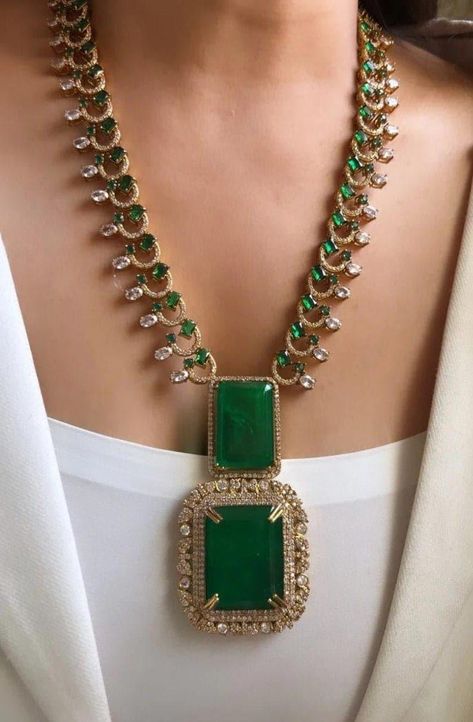 Sabyasachi Mukherjee's designs, this exquisite Victorian long necklace set with earrings encapsulates opulence and tradition in every detail. Crafted in a rich shade of emerald green, the doublet necklace features intricate embellishments that evoke the grandeur of Victorian-era jewelry. The necklace itself is a masterpiece of craftsmanship, adorned with delicate filigree work, sparkling crystals, and meticulously placed pearls. Each element is carefully chosen to reflect the luxurious aesthetic synonymous with Sabyasachi's creations, blending vintage charm with contemporary flair. The matching earrings complement the necklace perfectly, featuring cascading drops of green doublets surrounded by miniature pearls and crystals. Together, they create a harmonious ensemble that exudes sophistic Stones Jewellery Necklace, Antique South Indian Jewellery, Victorian Jewellery Designs, Emerald Necklace Indian, Long Neckless, Long Kundan Necklace, Victorian Jewelry Necklace, Cord Earrings, Punjabi Jewelry