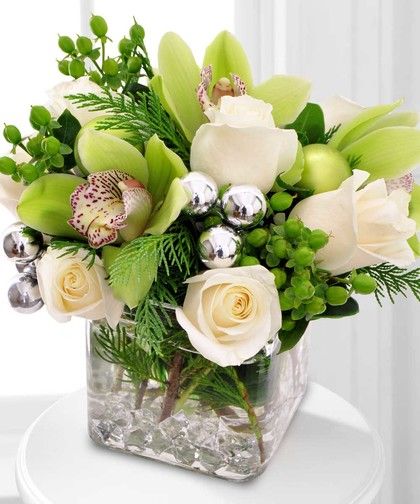 Silver ornaments and seasonal berries accent this festive holiday design comprised of pure white roses and green cymbidium orchids, with a touch of aromatic greenery. Small Arrangements, Green Centerpieces, Flower Christmas, Christmas Flower Arrangements, Diy Arrangements, Golf Theme, Christmas Floral Arrangements, Custom Bouquet, Cymbidium Orchids