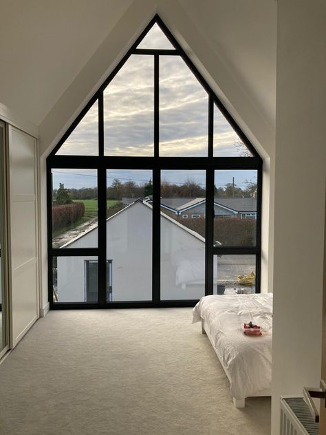 Views from inside a bedroom with a gable window with french doors inbetween