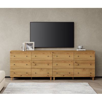 This 12-drawer TV dresser goes well with your bedroom, living room, or anywhere needs to be organized and stored. Each cabinet is equipped with an anti-tip kit which makes it perfect for households with children. Color: Oak Brown | Wade Logan® Bonis TV Stand for TVs up to 88" Wood in Brown | 32.4 H x 94.4 W x 15.3 D in | Wayfair Living Room With Dresser, Low Long Dresser, Extra Long Dresser Bedroom, Side By Side Dressers Master Bedrooms, 2 Dressers Side By Side, Dresser With Tv Mounted Above, Dresser Tv Stand Bedroom, Long Dressers Bedroom, Bedroom Dresser With Tv