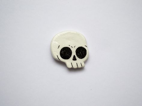 A hand sculpted skull clay pin. Perfect for those looking for a cool hand crafted accessory. Sculpted by hand with fimo clay, painted and sealed with a gloss resin varnish. Features a butterfly clasp on the rear. As each pin is made and finished by hand, there may be minor cosmetic differences between each pin. Seal Clay Sculpture, Clay Pins Diy, Clay Pin Ideas, Air Dry Clay Pins, Clay Badges, Beginner Clay Projects, Ceramic Pins, Clay Skull, Fimo Art