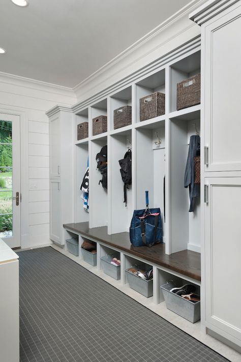 Long mudroom features closed cabinets flanking open mudroom lockers, one for each family member, lined with gray woven baskets over coat hook and galvanized metal baskets tucked under built in mudroom bench alongside a gray grid rug placed in front of glass mudroom door. Transitional Laundry Room, Farmhouse Mudroom, Mudroom Lockers, Mudroom Organization, Mudroom Entryway, Mudroom Laundry Room, Diy Mudroom Bench, Mudroom Design, Mud Room Storage