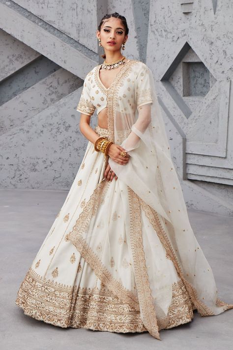 White lehenga with gold dori, aari and sequin embroidery. Comes with blouse and organza dupatta. Component: 3 Pattern: Embroidery Type Of Work: Sequin, Dori and Aari Neckline: V neck Sleeve Type: Half Fabric: Chanderi and Organza; Lining: Shantoon Color: White Other Details: Dupatta with embroidered cutwork border Blouse with curved hem Cutwork detail waistband Note: Only selling the product mentioned in the description from the video. Occasion: Wedding - Aza Fashions Pastel Bridal Lehenga, Double Dupatta, Ivory Lehenga, Pastel Lehenga, Embroidery Zardozi, White Lehenga, Raw Silk Lehenga, Diana Penty, Karisma Kapoor