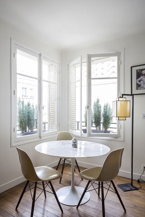 Small Paris apartment living room with Saarinen dining table and windows with pocket shutters, a design by architect Philippe Harden Paris Apartment Living Room, Small Apartment Dining Room, Tiny Dining Rooms, Small Apartment Furniture, Dining Room French, Apartment Dining Room, Apartment Dining, French Country Living Room, Small Apartment Design