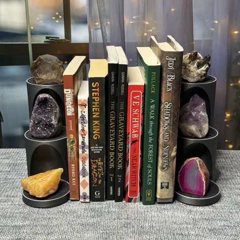 "PLEASE READ THE DESCRIPTION BELOW BEFORE PURCHASING: (NOTE THE SIZES. The stand size can also be seen in the listing photos.) This listing is for a set of Bookends. You will receive 2 mirrored Bookends, one for each side of your books. You can now customize your crystal stand! Choose the Primary Color -and- choose an Accent Color. Use the pull down menu to make your selections. The filament colors are shown in the listing photos. Show off 6+ of your favorite crystals with this new Bookend Displ Crystal Organization Display, Crystal Decor Ideas, Crystal Collection Display, Unique Bookends, Crystal Stand, The Graveyard Book, Crystal Display, Black Shadow, Booth Display