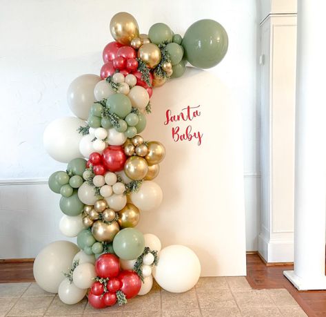 15 Best December Baby Shower Ideas - www.mummytries.com Christmas Gender Reveal Balloon Arch, Christmas Party Balloon Arch, Christmas Baby Shower Balloon Arch, Christmas Gender Reveal Decorations, Christmas Arch Decor, Xmas Baby Shower Theme, Grinch Theme Baby Shower Ideas, Santa Baby Gender Reveal, Christmas Balloon Arch Ideas