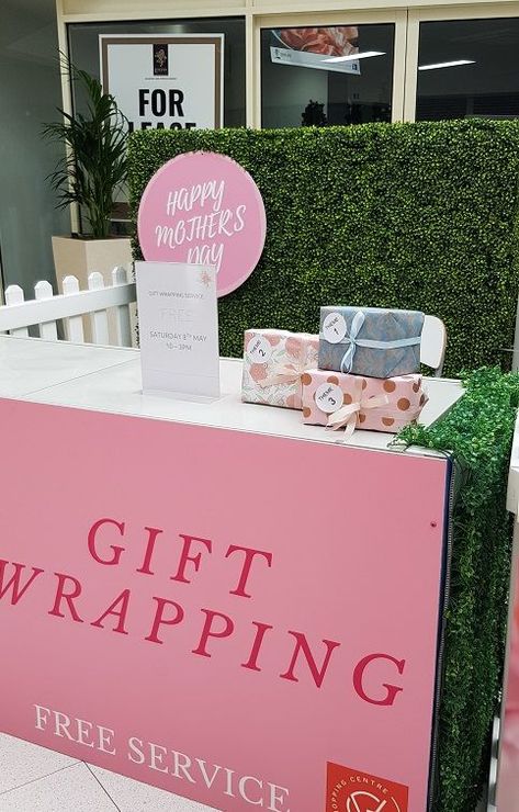 Desk with giftwrapping front banner, with a hedge wall behind. Gifts wrapped sit on the desk. Christmas Retail Display, Christmas Retail, Gift Wrapping Station, Wrapping Station, Sale Promotion, Branded Gifts, Retail Display, Christmas Sale, Happy Mothers