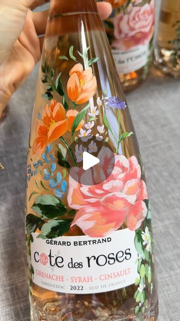 nhbydesign em August 28, 2024: "Hand painted rosé bottles for K+D’s wedding 💐 Had so much fun designing these bottles to match the colorful florals on their wedding day 🤍 imagine them on a cute little bar cart serving as decor and a memorable keepsake ✨ —— #bottlepainting #floralpaintings #bottlepainting🎨 #weddinggiftideas #bottlepaintings #paintedbottles #bayareaartist #sfbottlepainting #bridalgifts #gerardbertrand #custompainted #bottlepainter". Floral Wine Bottle, Bottle Paintings, Beverage Branding, Hand Painted Bottles, Colorful Florals, Painted Wine Bottles, Custom Bottles, August 28, Bottle Painting