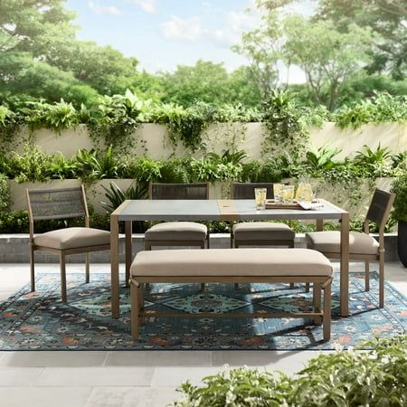 Enjoy dining and conversations outdoors with the Better Homes & Gardens Tarren 6-Piece Steel Outdoor Dining Set. This casual and stylish set includes four cushioned chairs, one cushioned bench, and one rectangular dining table. The low-back design and neutral-toned frames with tan cushions and a light-gray tabletop complement any outdoor furniture and decor. Constructed with e-coated and powder-coated steel frames and 50% recycled polyester cushions, this set is durable and long-lasting. Perfect for cookouts, dinner parties, or simply relaxing outdoors, the Tarren 6-Piece Steel Outdoor Dining Set is a comfortable and stylish addition to any porch, patio, or deck. Small Patio Dining Table, Outdoor Dining Table With Bench Seating, Small Patio Dining Ideas, Tan Cushions, Modern Outdoor Dining Sets, Table With Bench Seat, Square Patio Table, Cushioned Bench, Charleston House